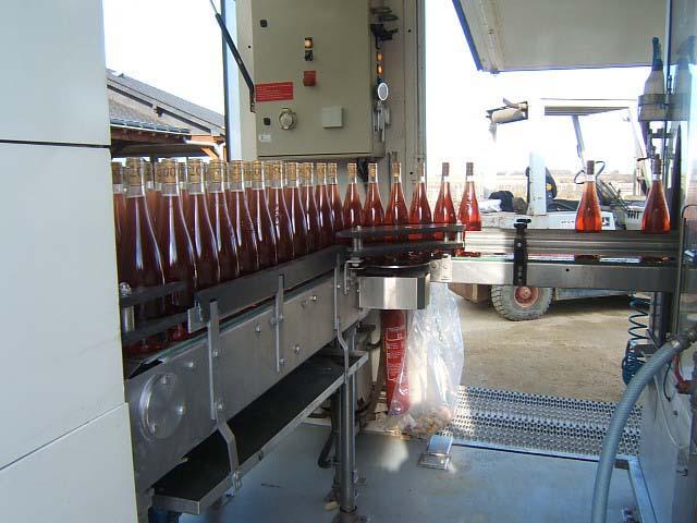 meb18.JPG - En sortie de boucheuse les bouteilles rejoignent une table d'accumulation.